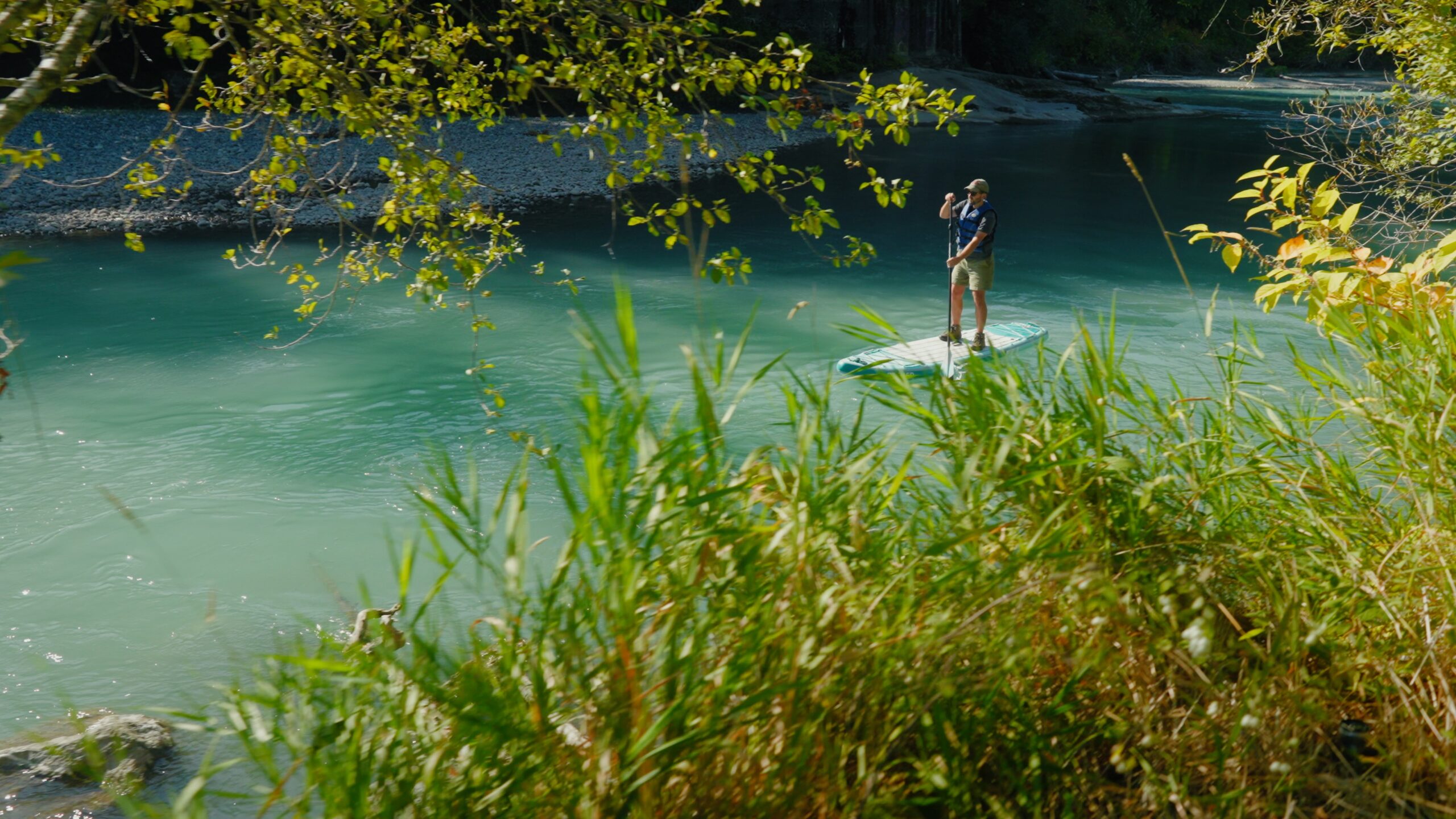 A person standing on a paddleboard in a river